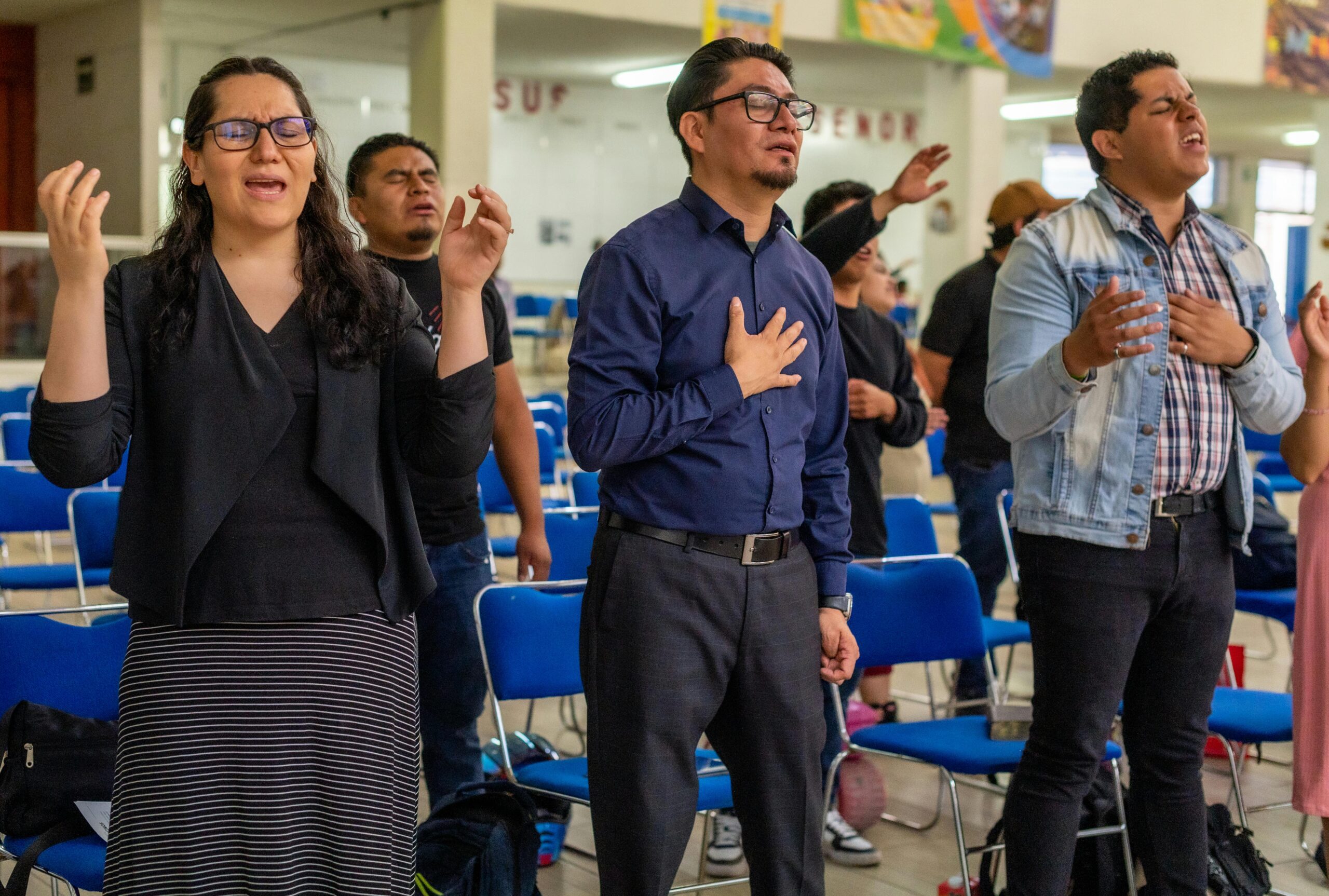 Home Individuals engaged in a worship session, expressing devotion and praise.